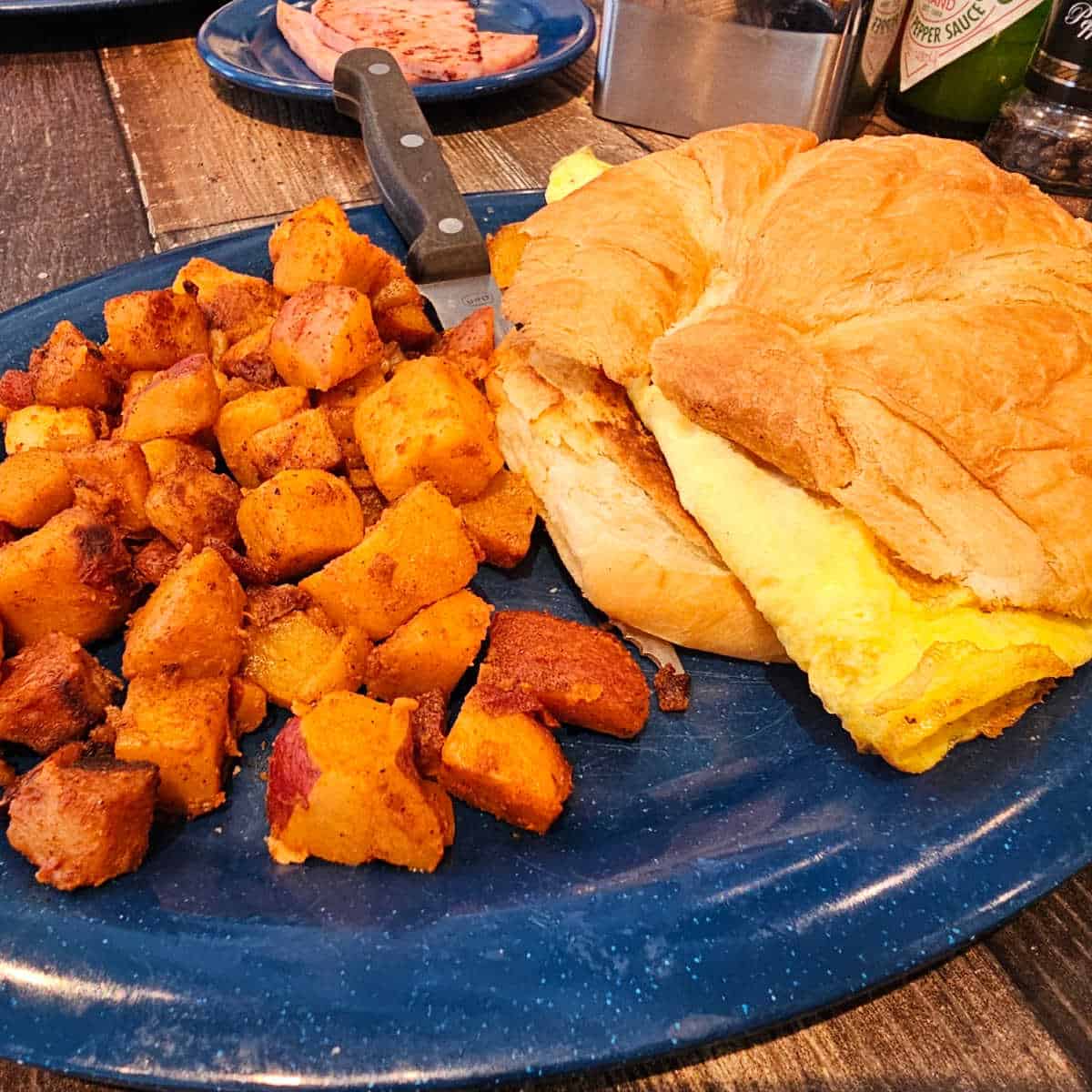 Delicious breakfast sandwich featuring fluffy eggs, melted cheese, and a flaky croissant served with.