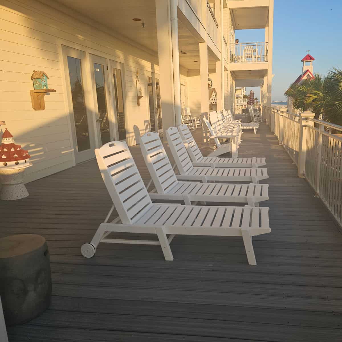White deck chairs in a line along the Driftwood Inn with a red and white building in the background