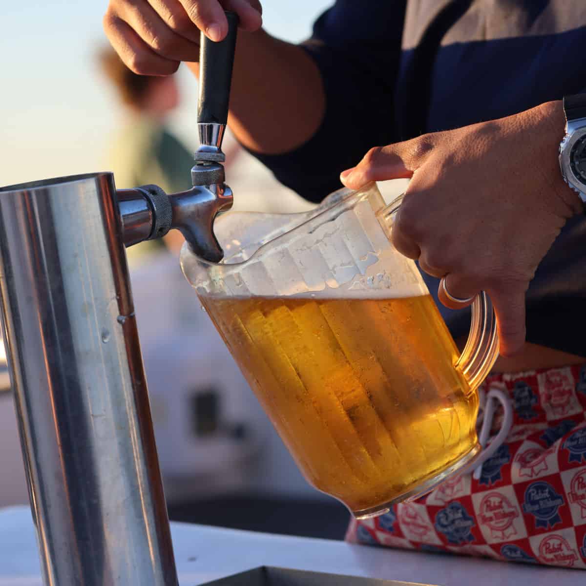 beer being poured into a pitcher from a spout