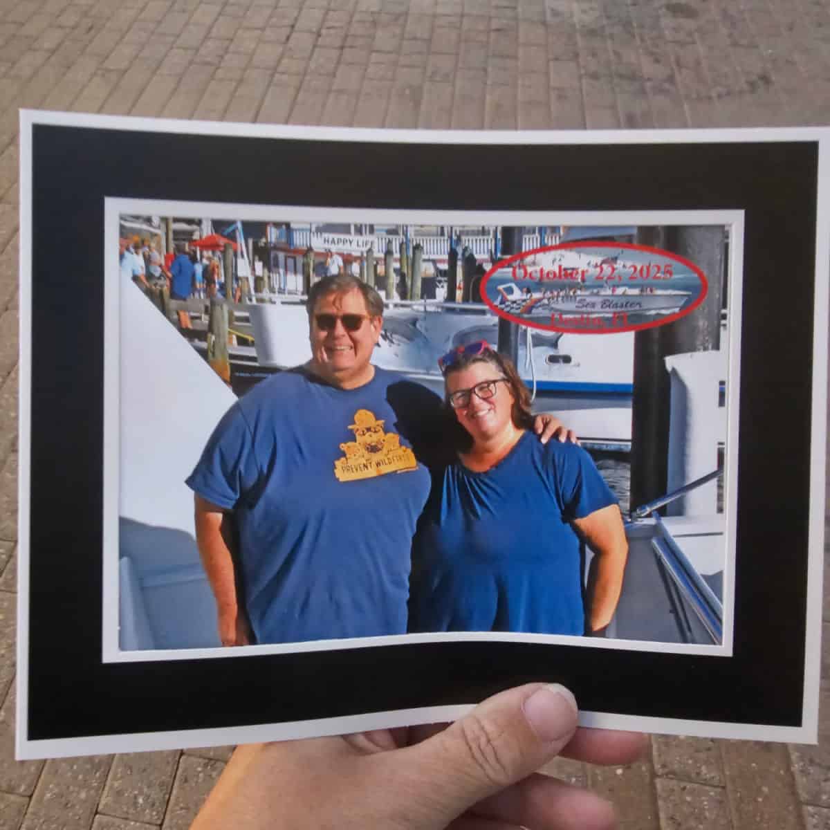 hand holding a photo of tammilee and john on the Sea Blaster boat