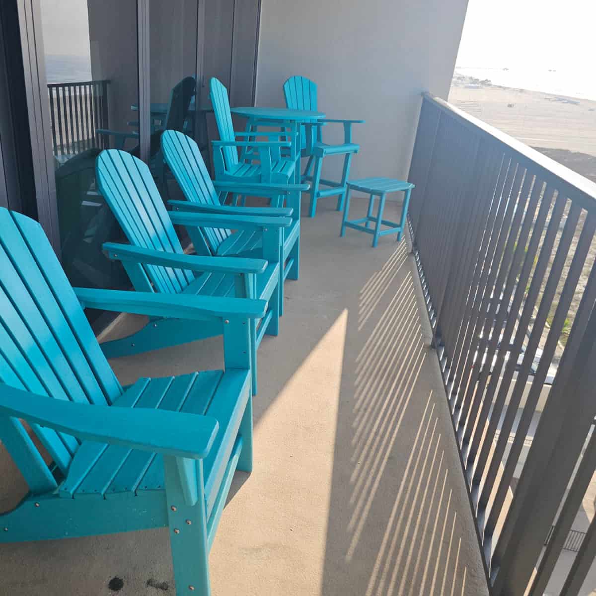 Blue Adirondack chairs lining a balcony