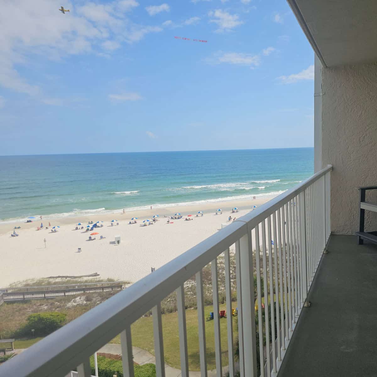 Looking over a balcony to the sand and Gulf waters in the background