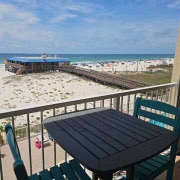 balcony with table and chair, looking out to the beach and Sea N Suds restaurant.