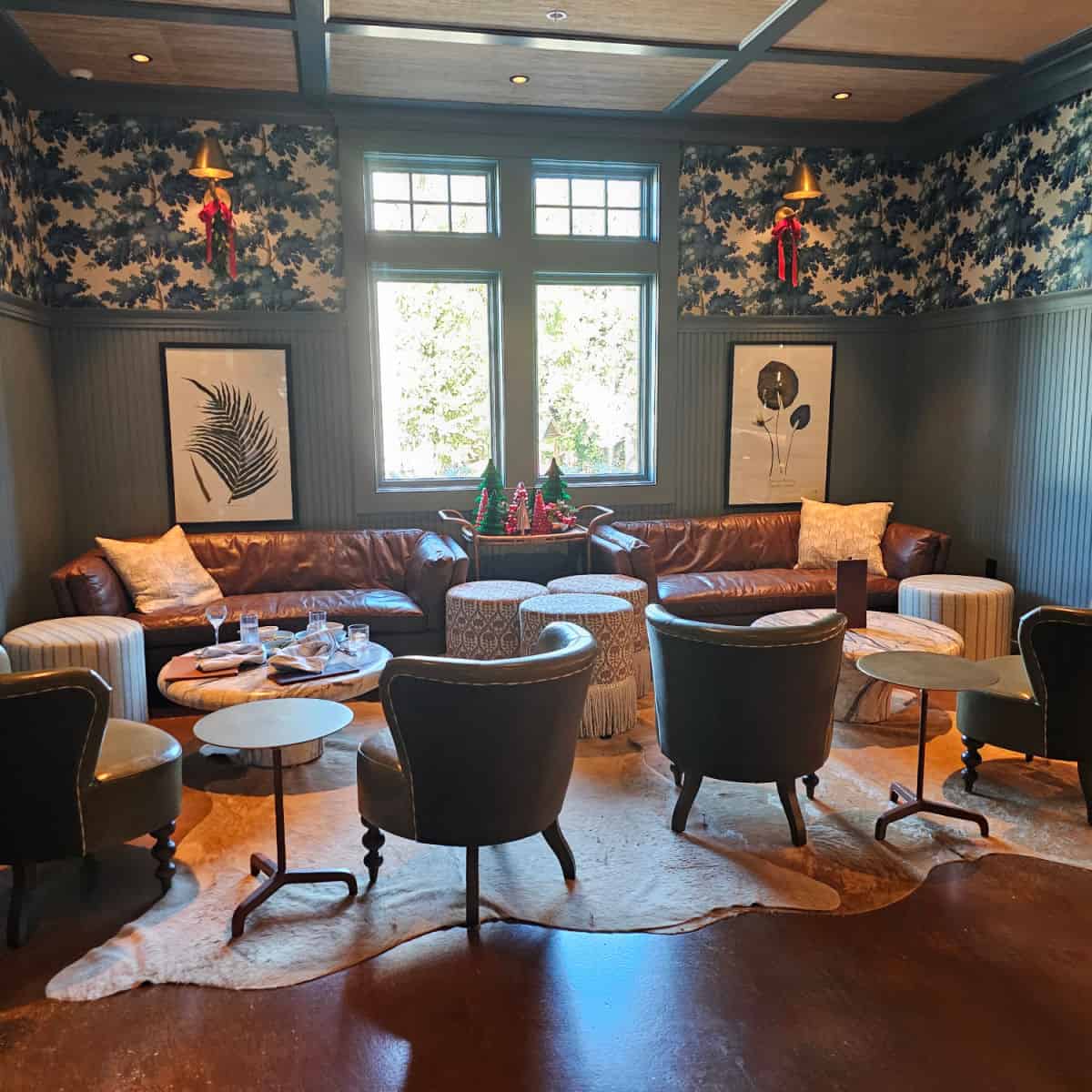 Ginny Bar seating with two leather couches, poofs, and chairs around low tables