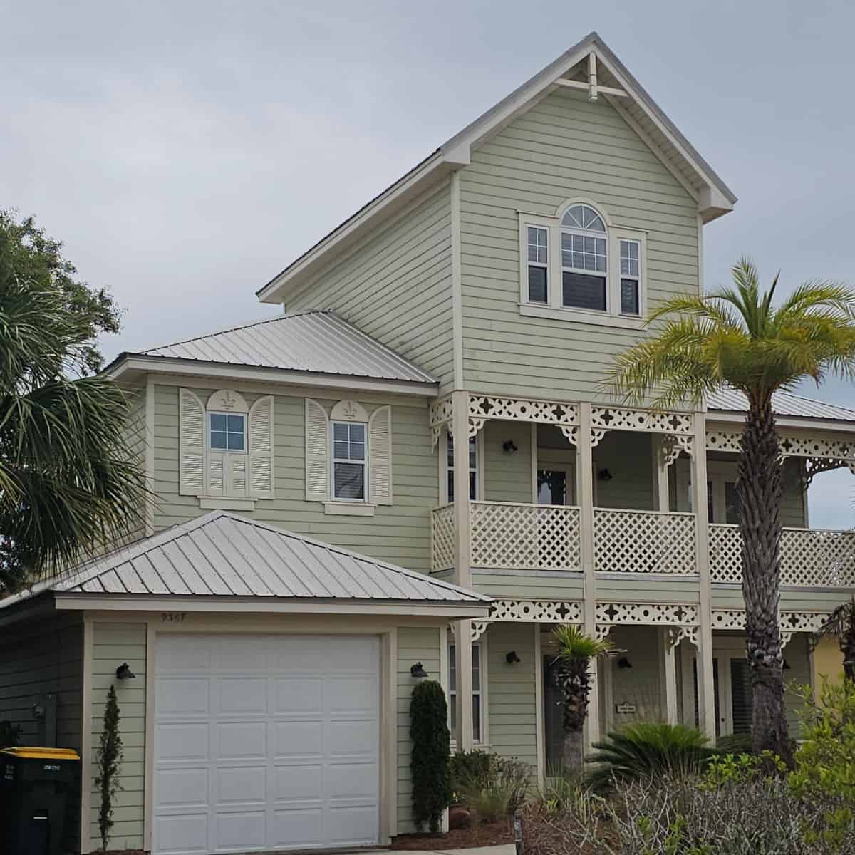 green multi story house with palm trees