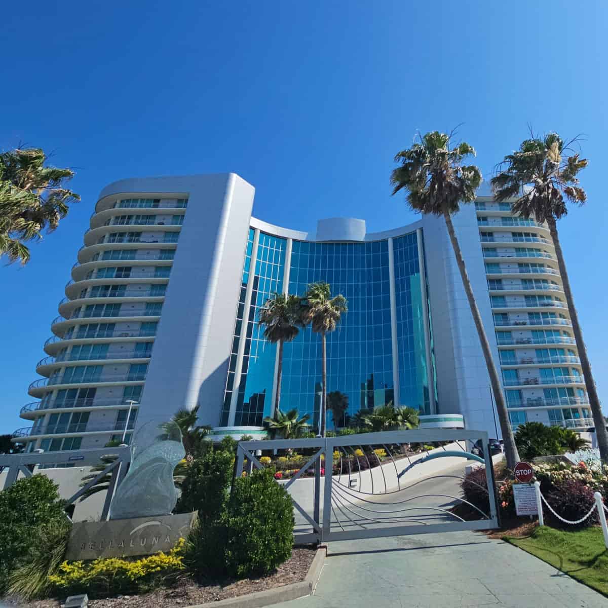 Bella Luna condominium building with tall palm trees by the security gate