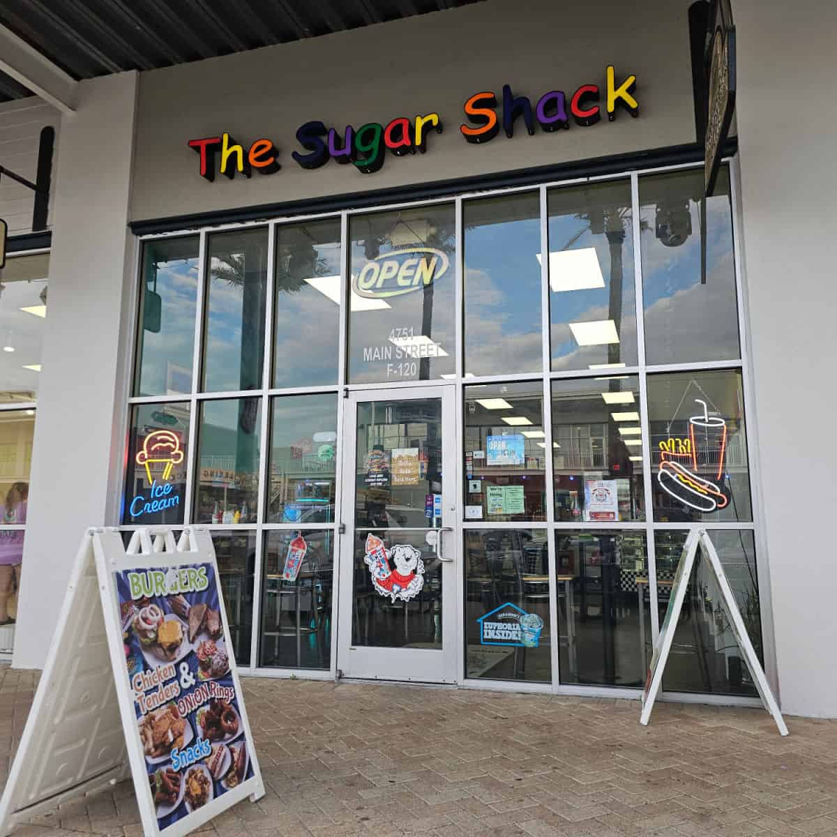 The Sugar Shack colorful letters over glass windows with the door to the shop