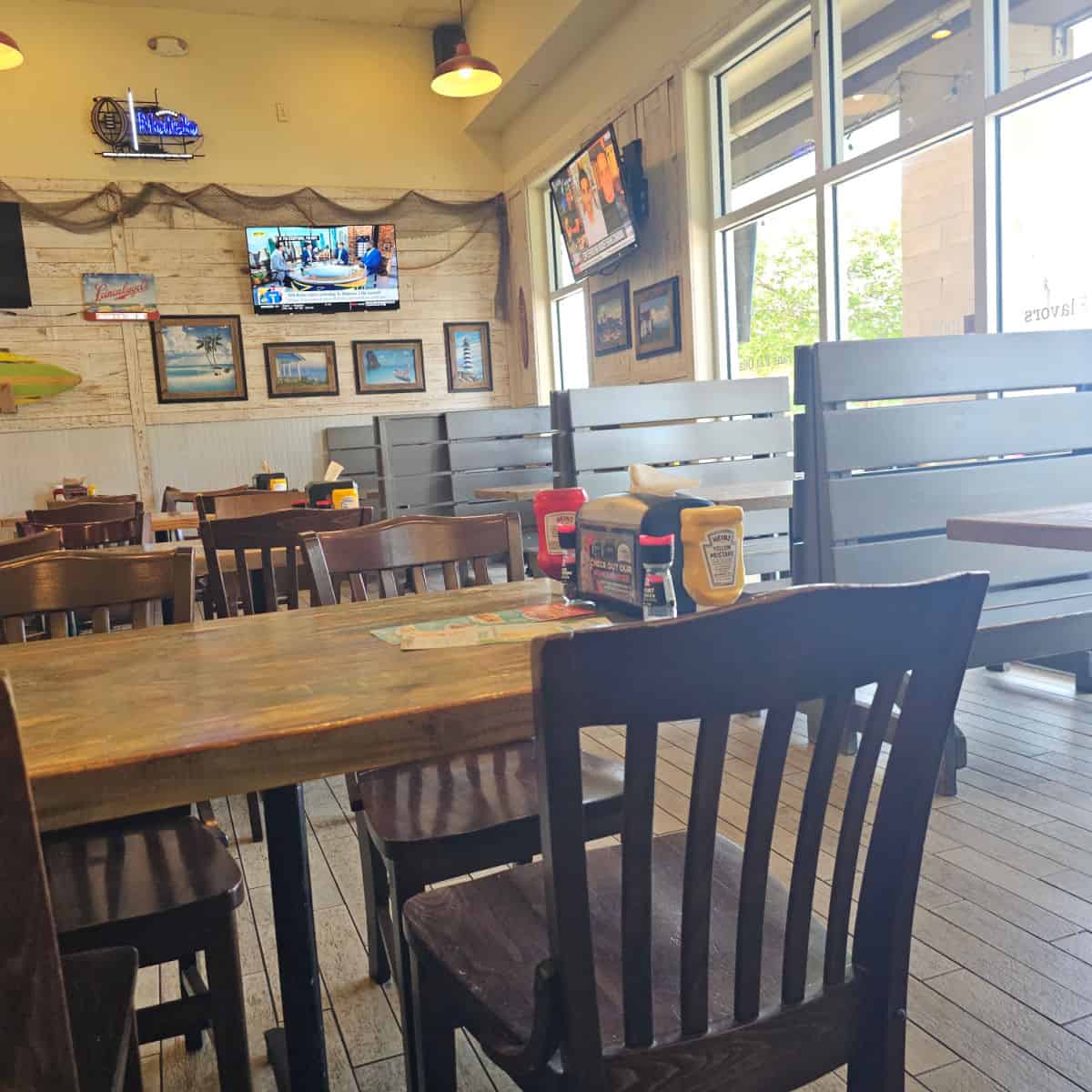 indoor seating with benches and tables along the wall, tables and chairs through the middle of the restaurant