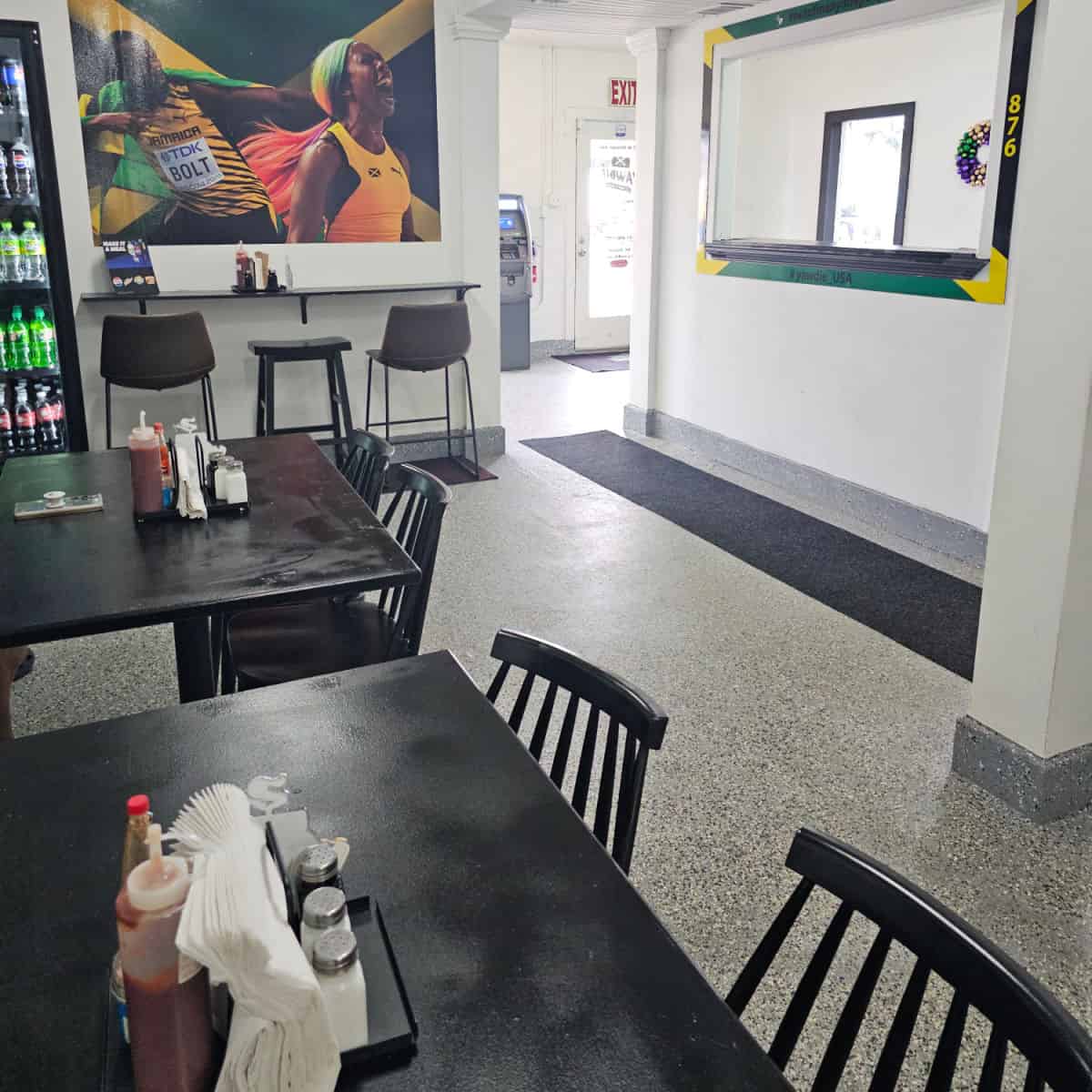 Indoor seating with tables and chairs, Jamaican flag art on the wall