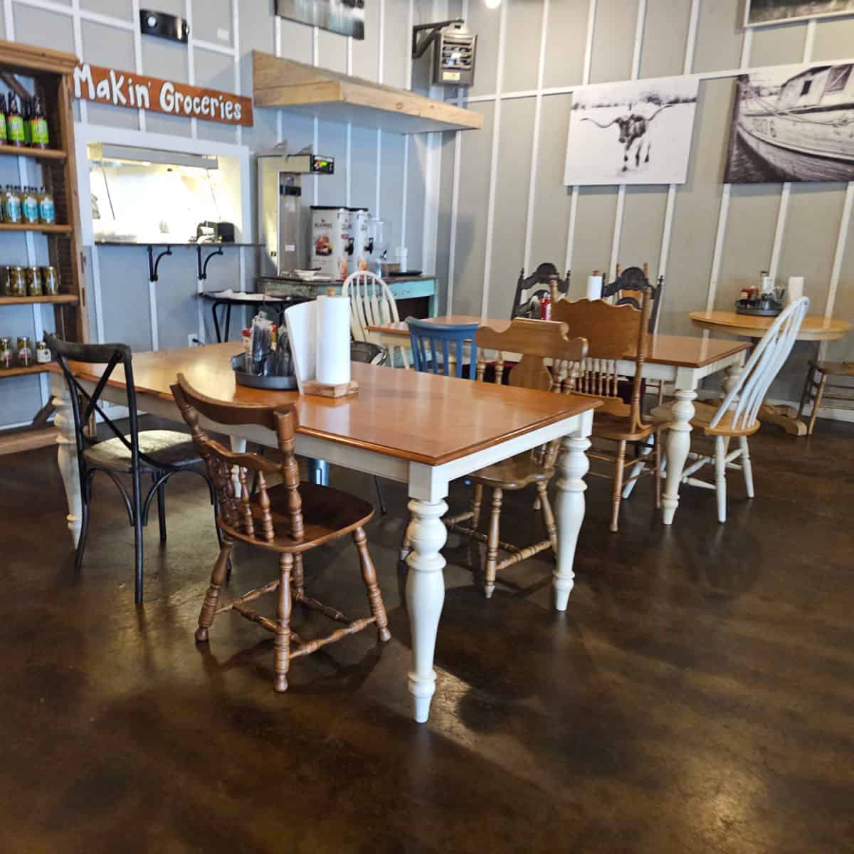 Indoor seating with tables and chairs, makin groceries sign on the wall