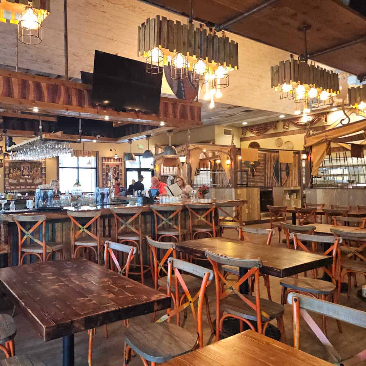 Indoor seating with tables and chairs, bar stools along a tall stool