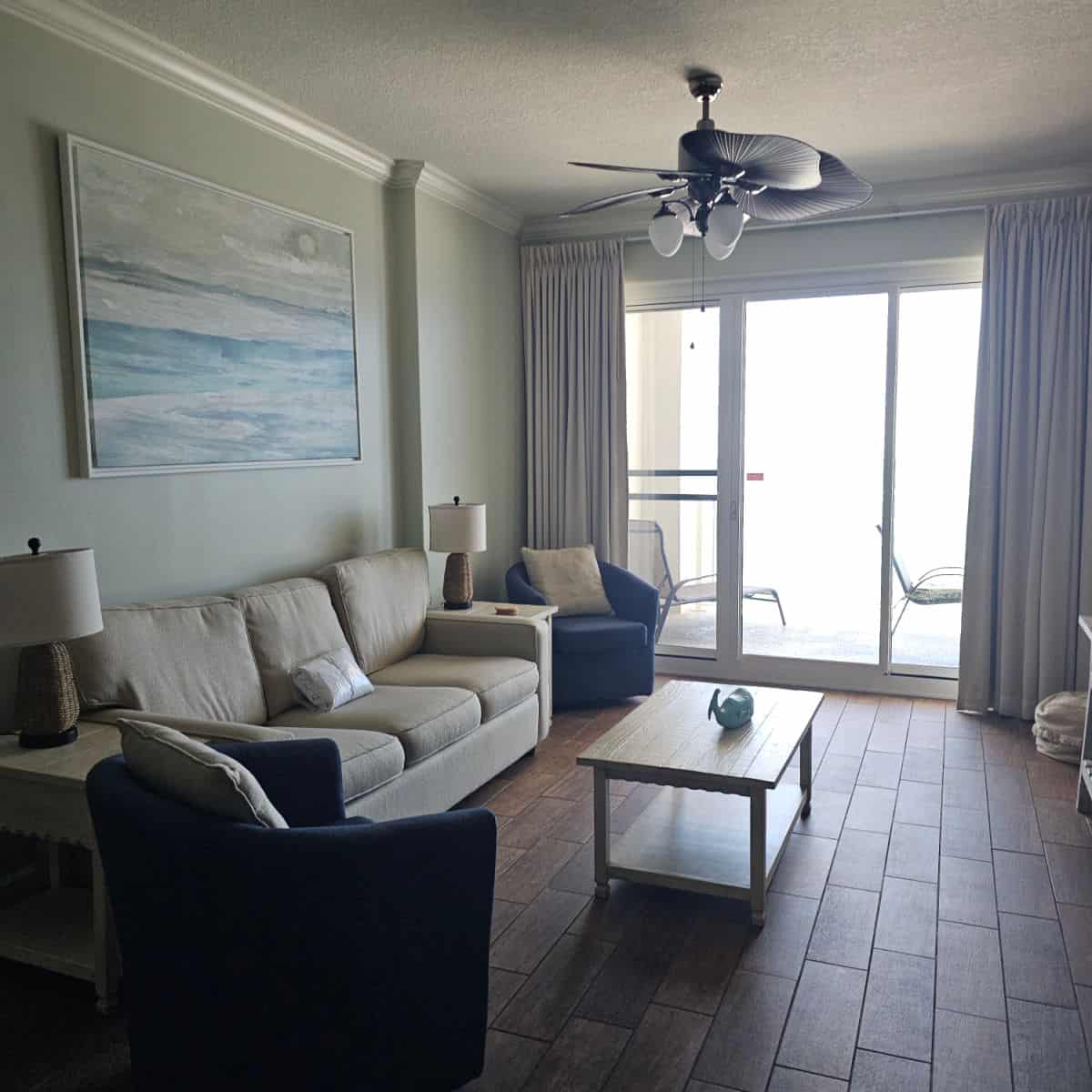 living room with a white couch, table, and bright light at the window