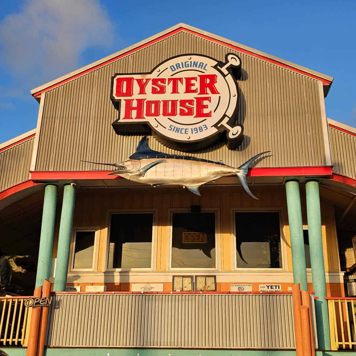 the Original Oyster House since 1983 sign over a large mounted fish on the side of the restaurant
