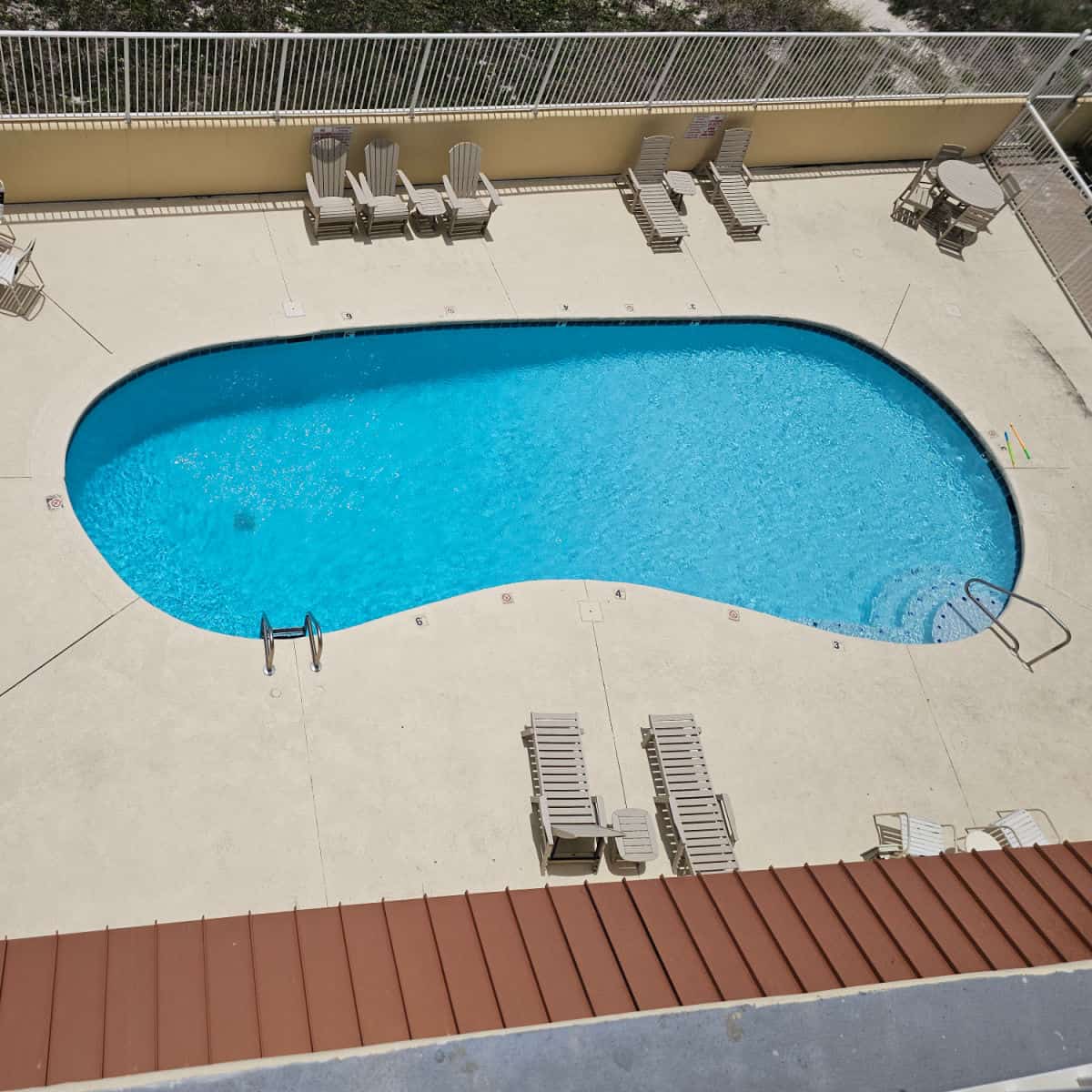 looking over the outdoor pool with deck chairs around the pool deck