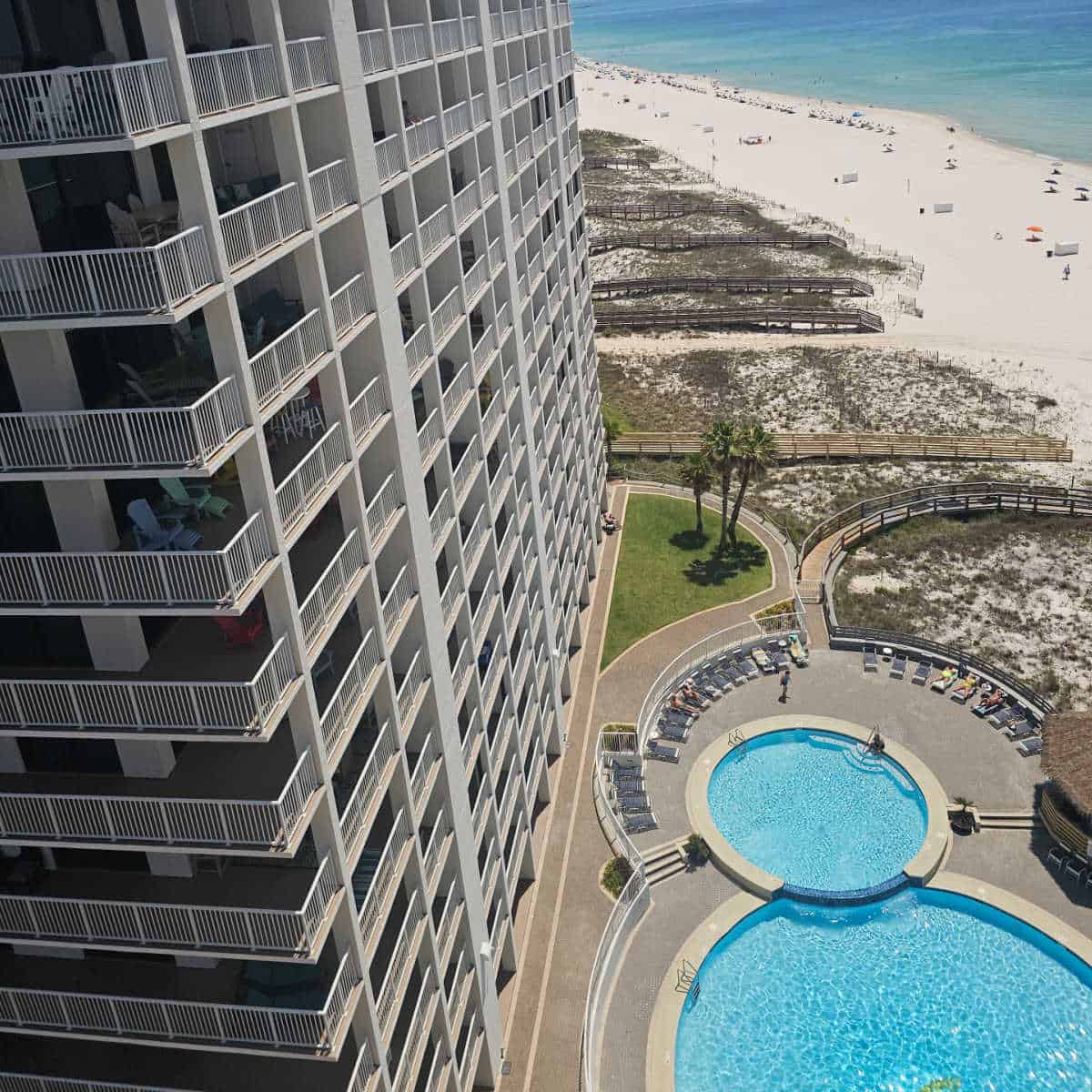 looking down the side of Summer House to two pools, sand dunes and then the beach and Gulf