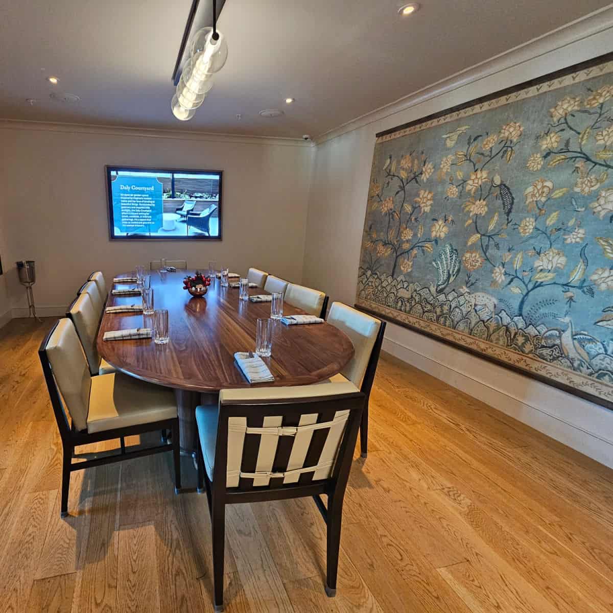 The Starling Room with long table and chairs, blue tapestry on the wall, flatscreen tv on the far wall