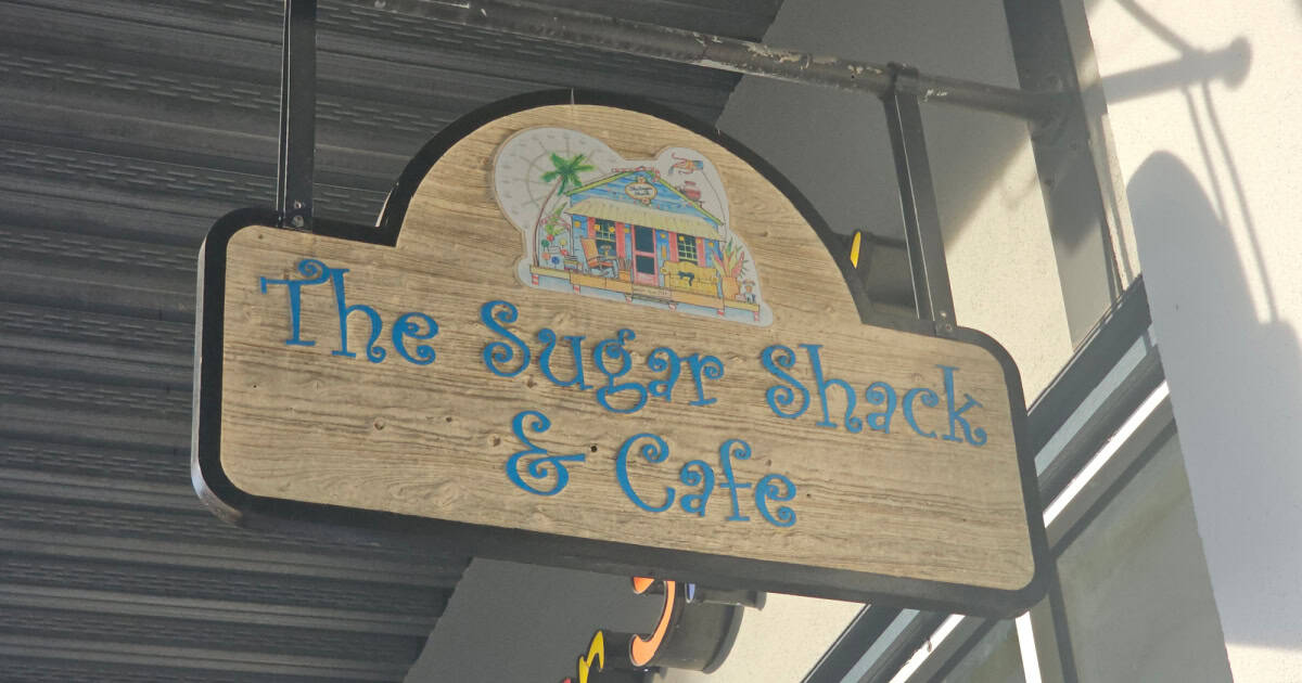 The Sugar Shack & Cafe sign with a small cabin on it