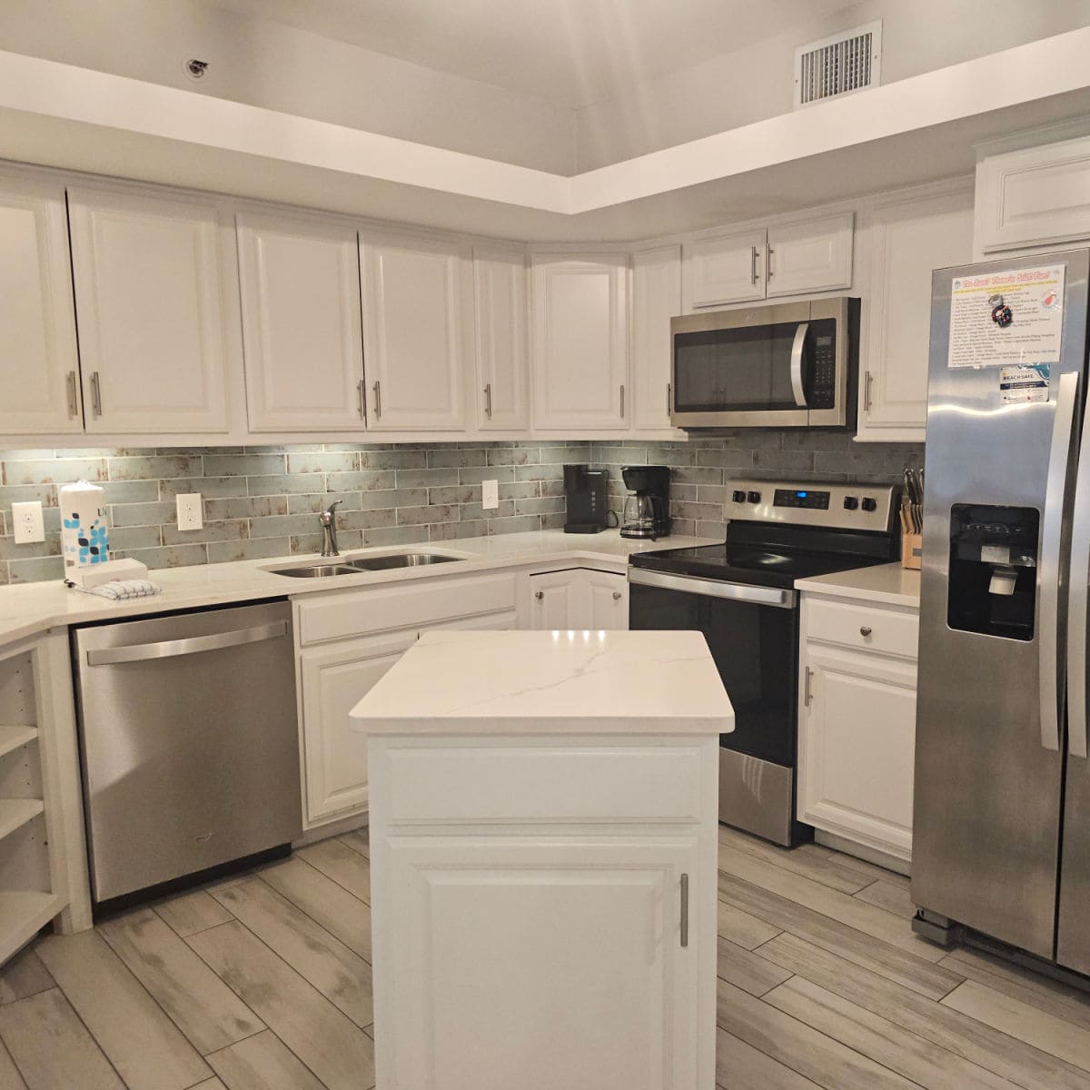 Kitchen with stainless steel appliances small island in the middle, white cabinets