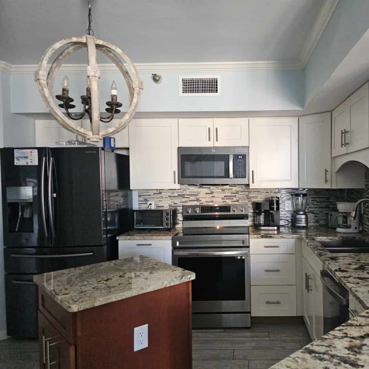 Kitchen with a small island in the middle chandelier from the ceiling
