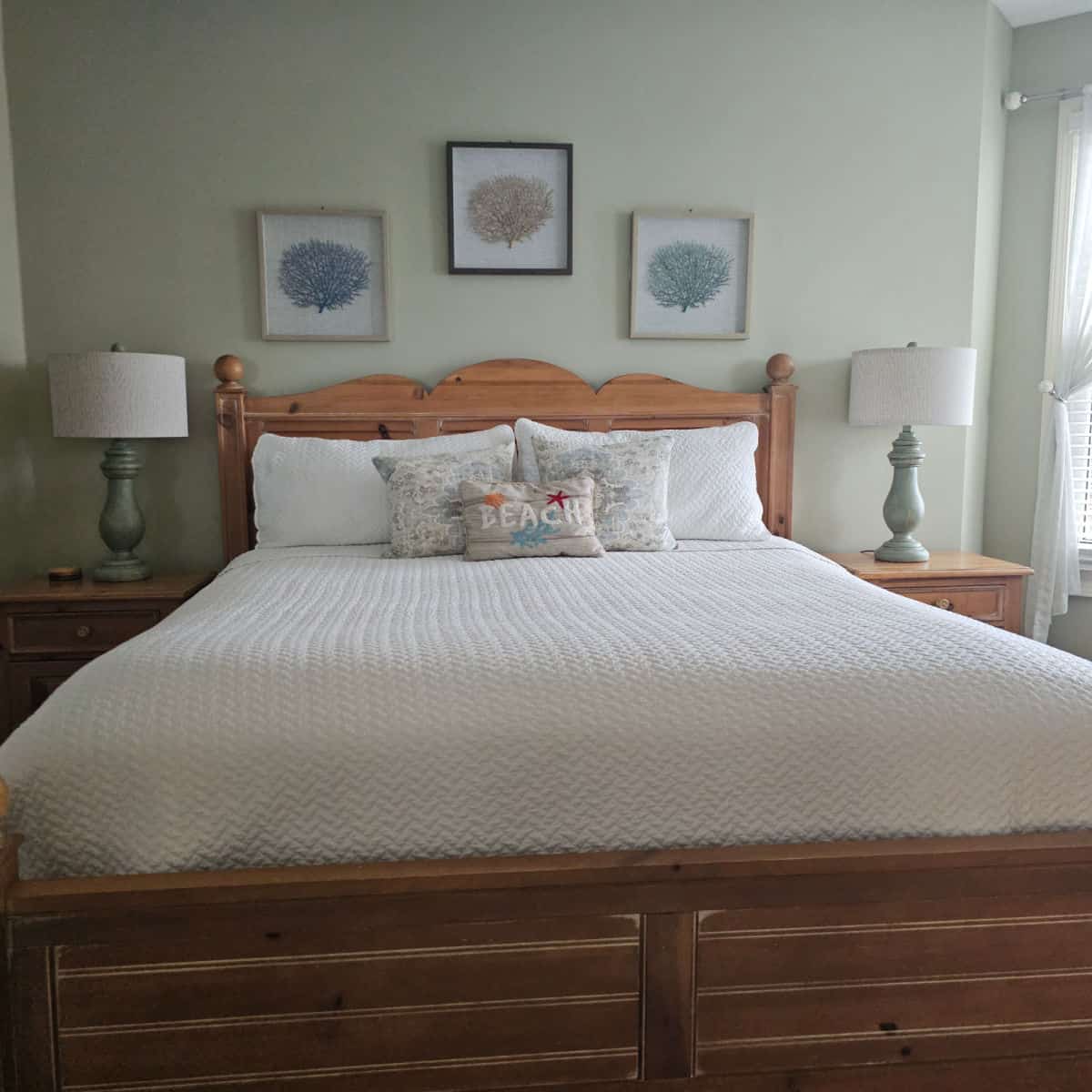 king size bed with wooden bedframe with prints on plants on the wall