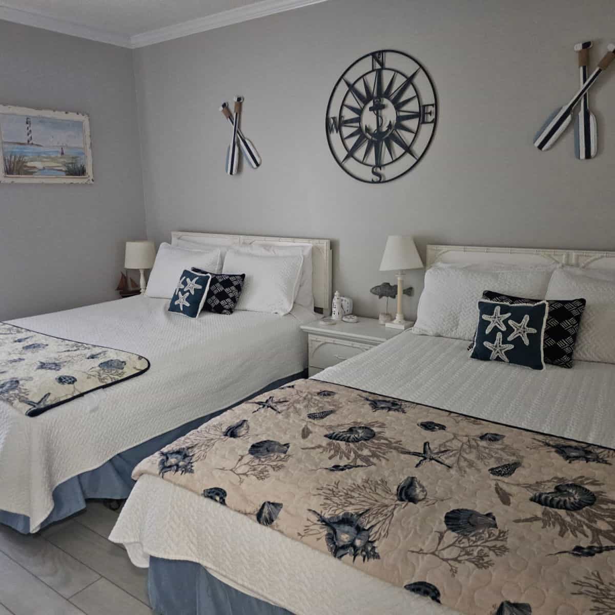 bedroom with two beds, oars and compass on the wall