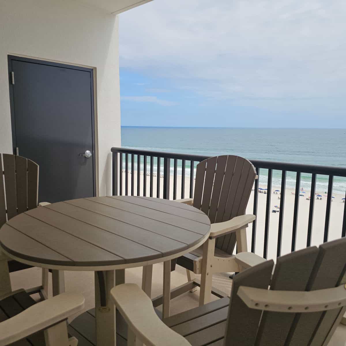 deck table and chairs on a balcony looking over the beach
