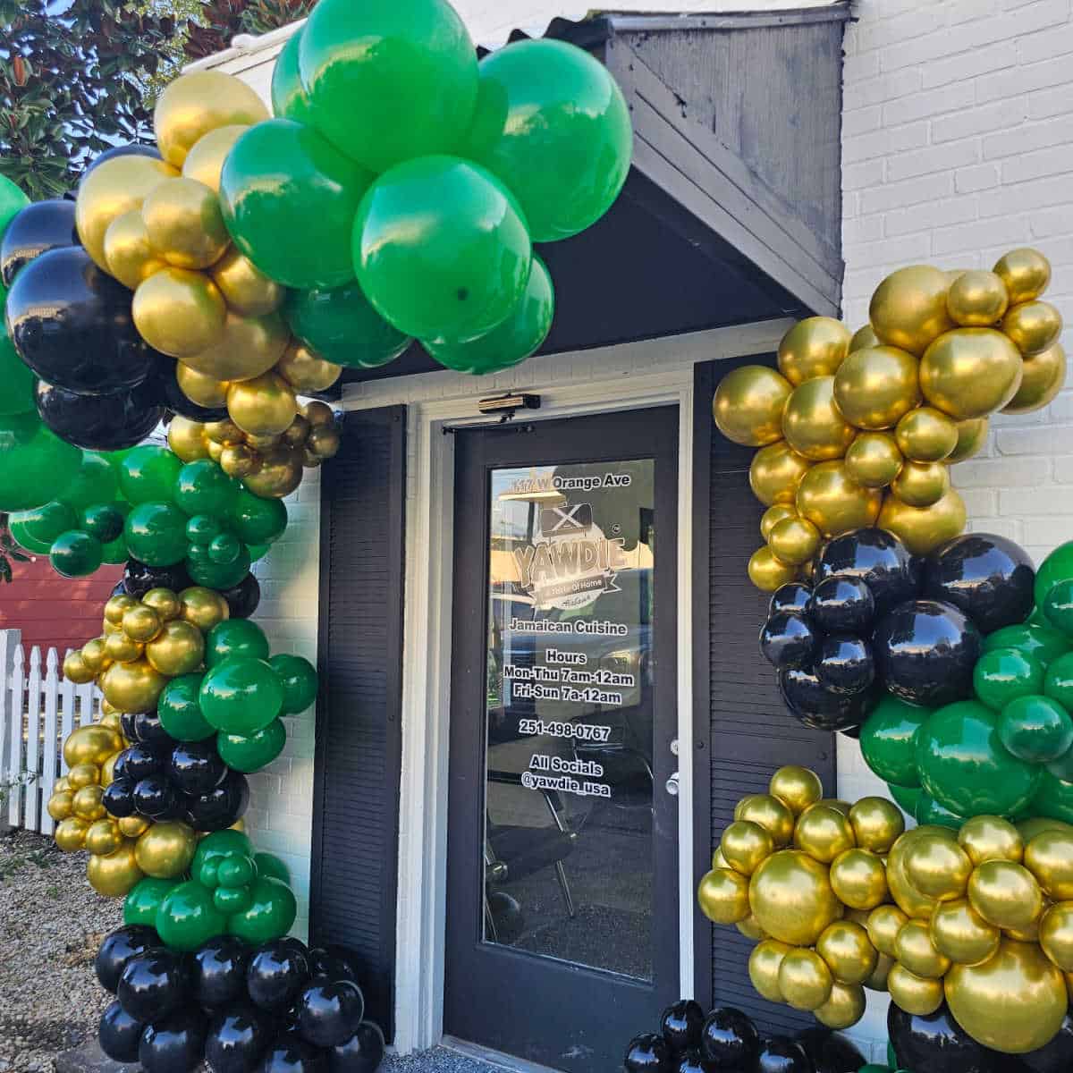 green gold and black balloons around the Yawdie Restaurant door