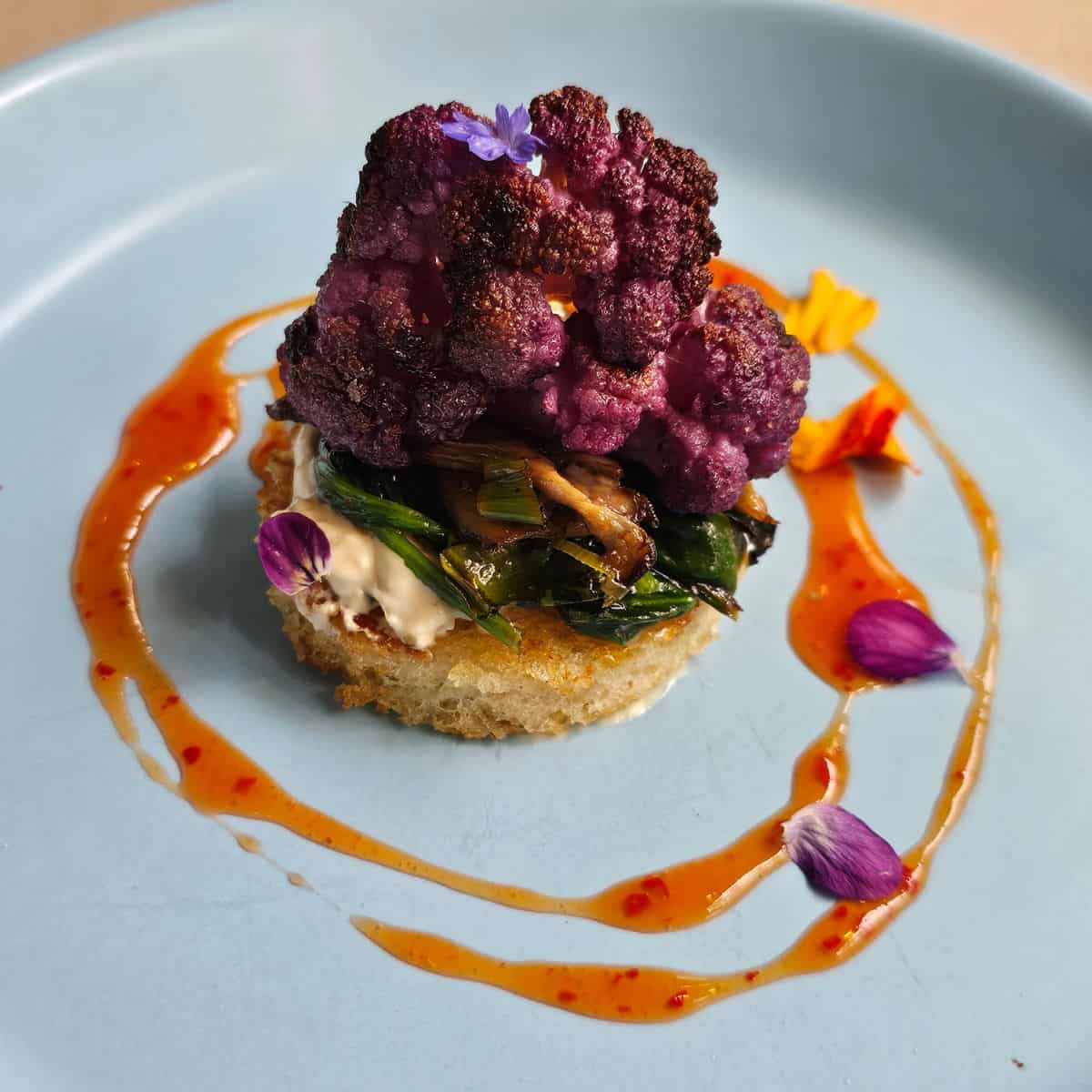 vegetable dish with a ring of oil around it on a blue plate