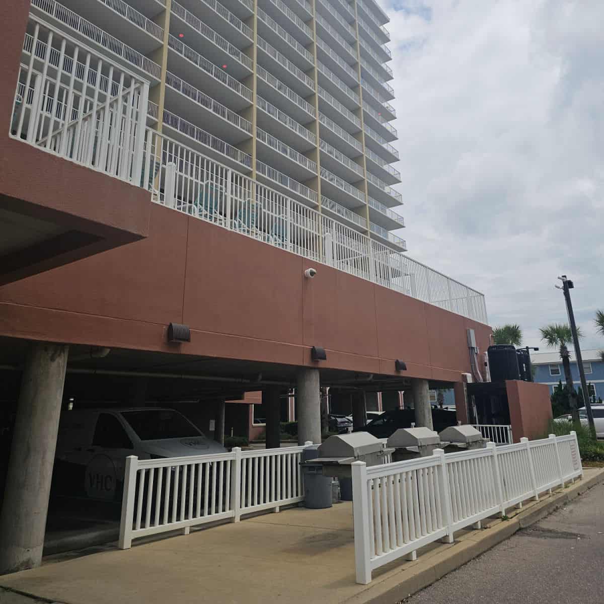 barbecue area behind white fences and building in the background.