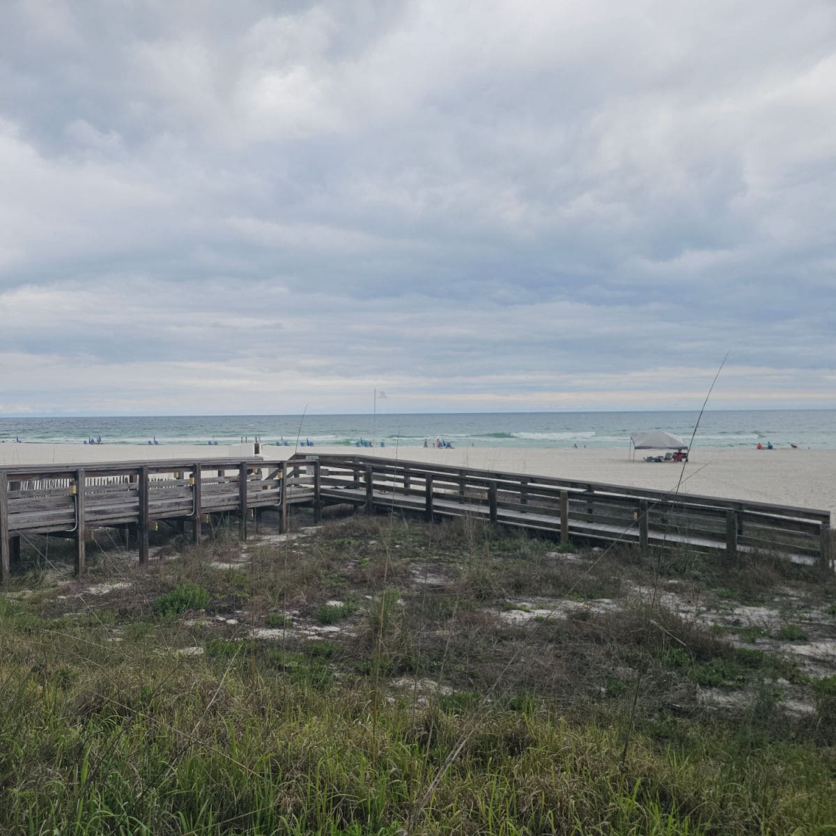 wooden ramp over sand dunes with the beach and Gulf in the background.