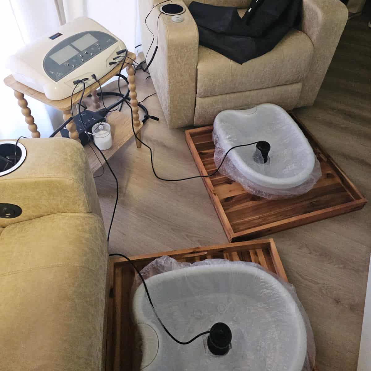 foot baths on a wooden plate, next to recliner chairs