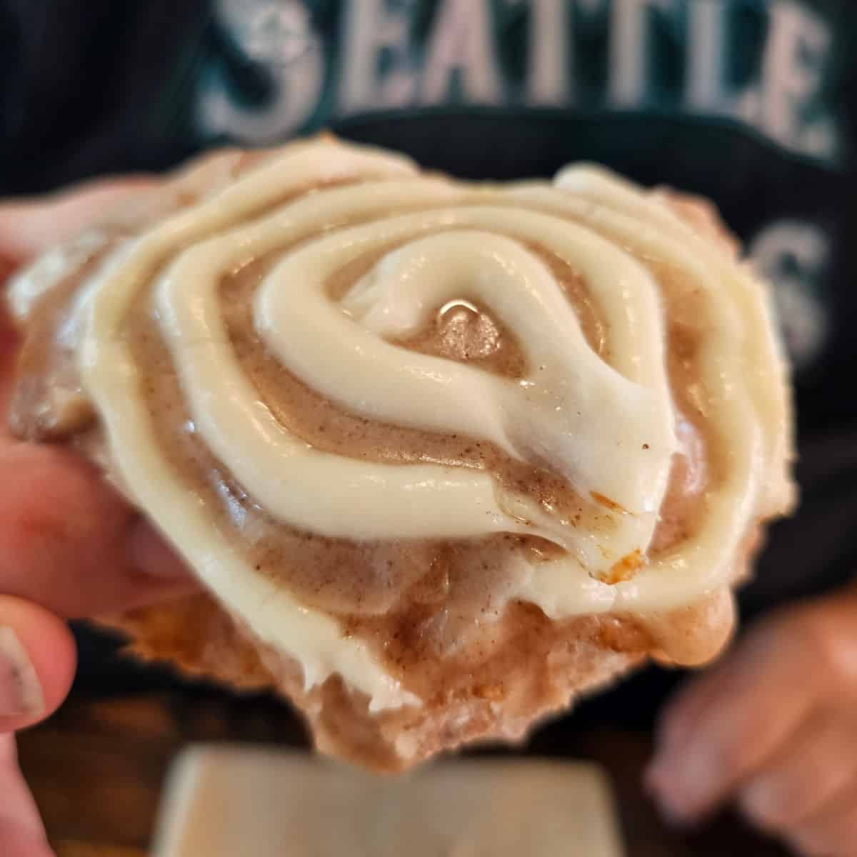 hand holding an iced doughnuts