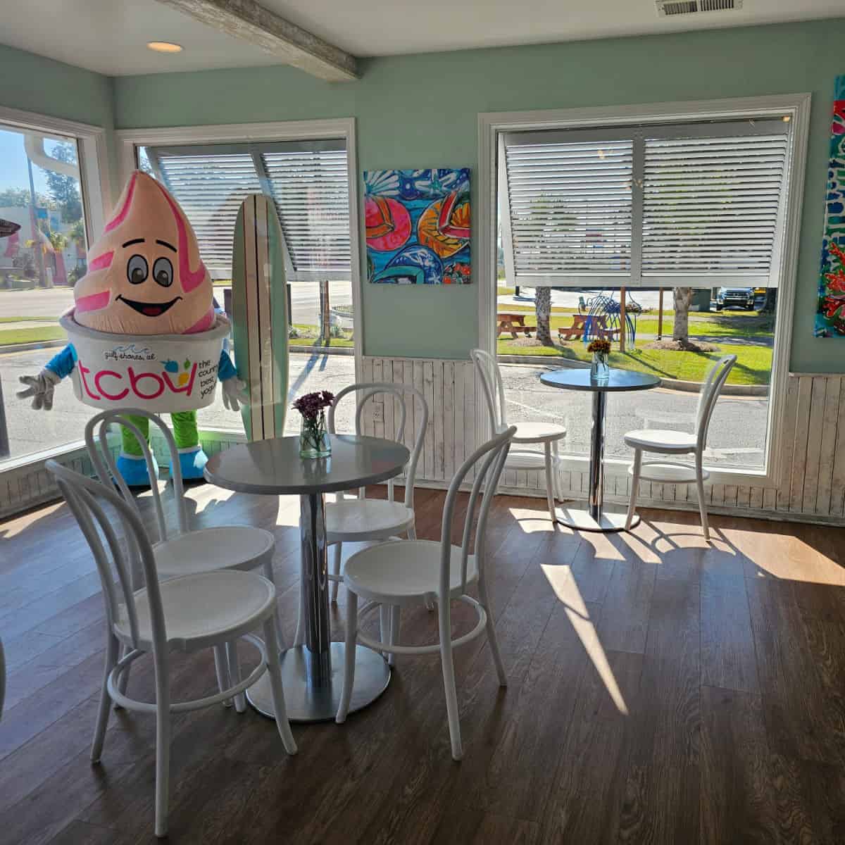 insideTCBY with a TCBY figure in the corner, white chairs next to a table
