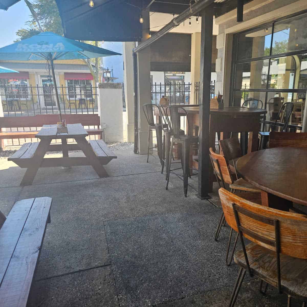 outdoor seating area with tables and chairs along with picnic table with blue umbrella