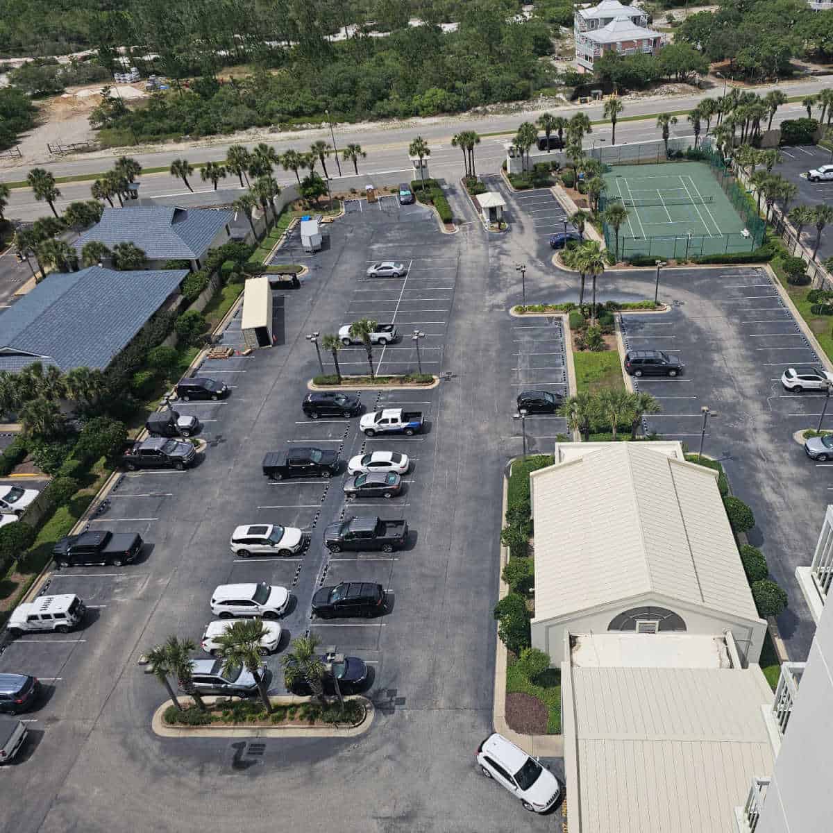 looking over the parking area with a tennis court in the far corner