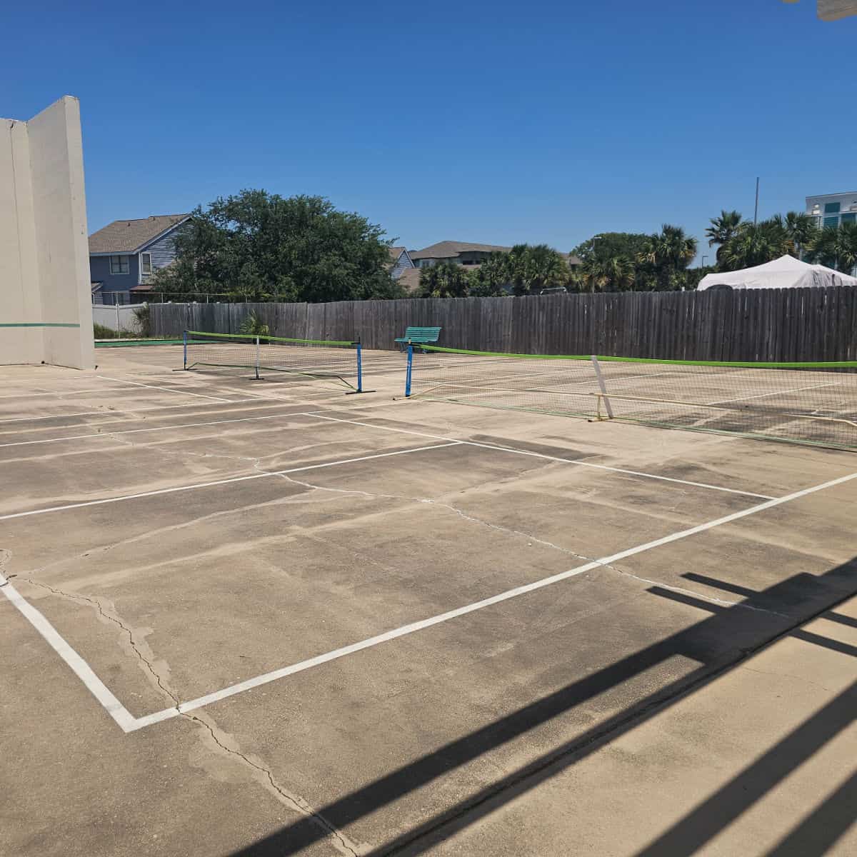 concrete pickleball court with fence along the back