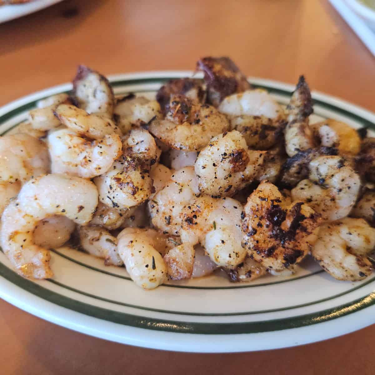 whit eplate with blackened popcorn shirmp piled on it.