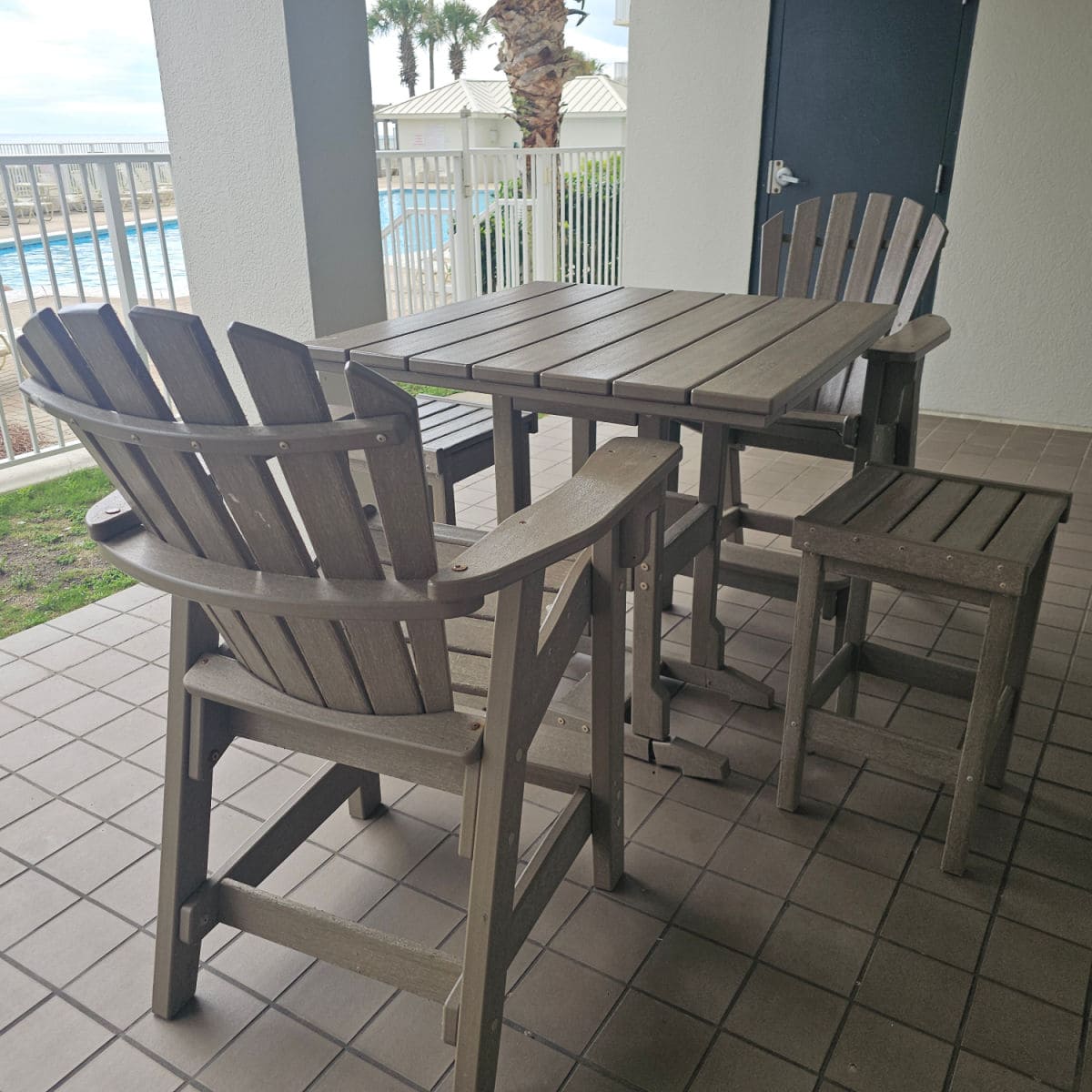 small table with adirondack chairs on the deck looking out over the pool deck