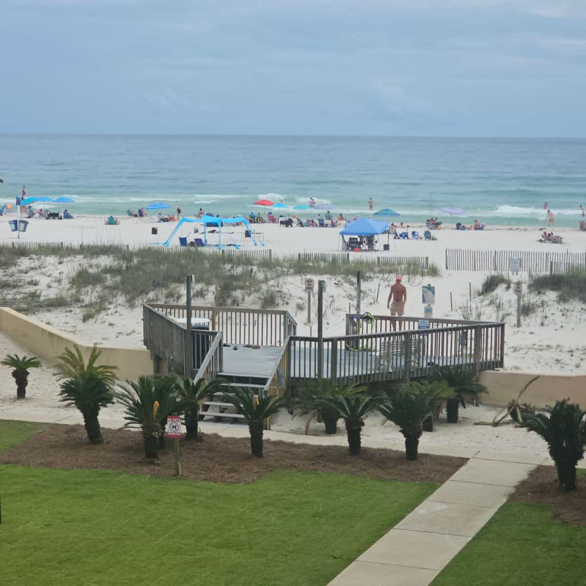looking out to a platform leading to the beach with beach tends and the Gulf in the background