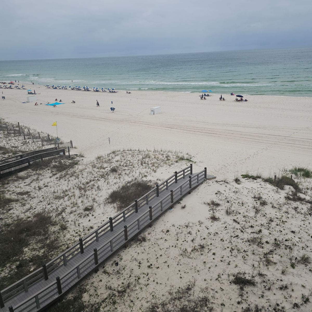 looking down on a walkway over the sand dunes to the beach and Gulf water
