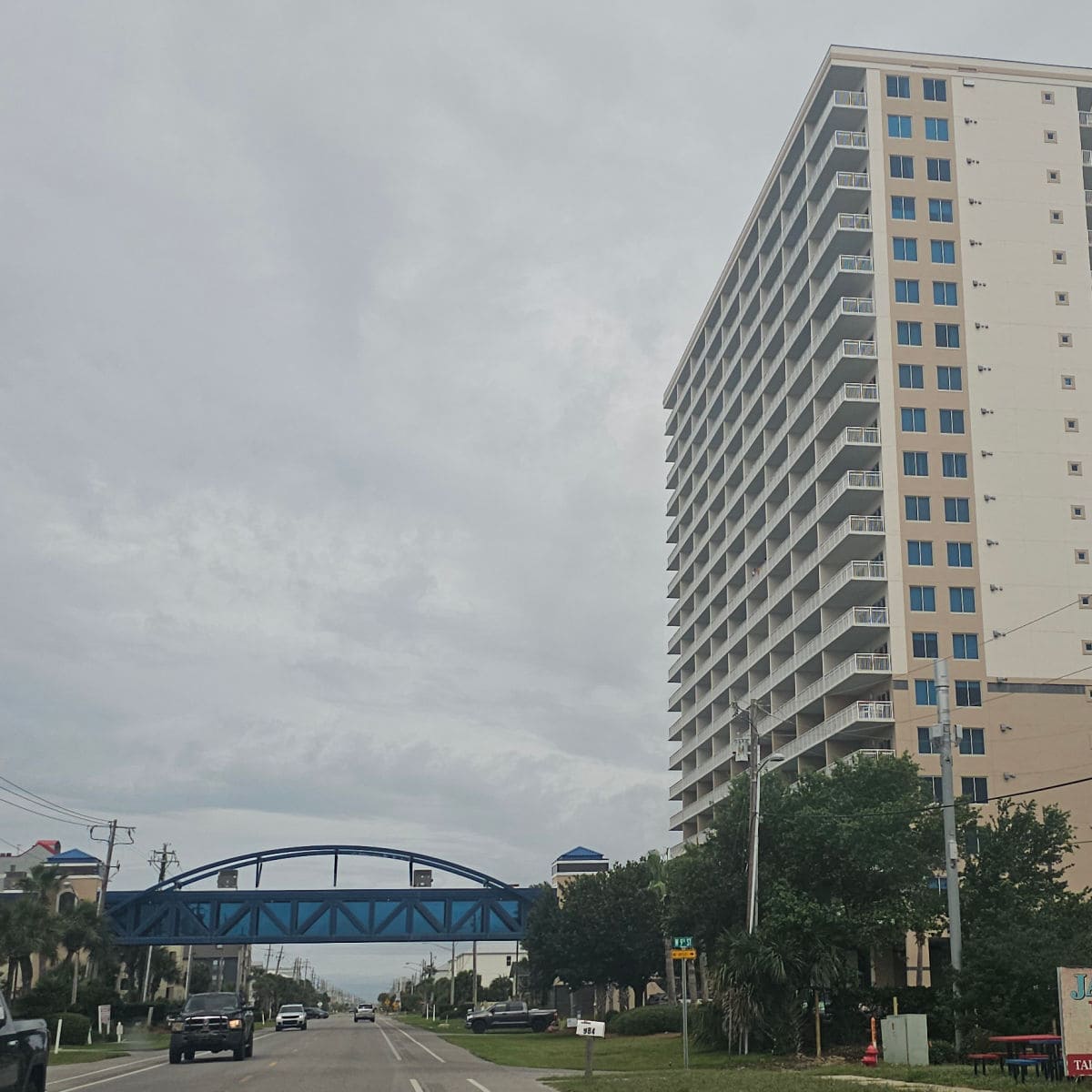 crystal tower exterior with a pedestrian bridge over West beach blvd