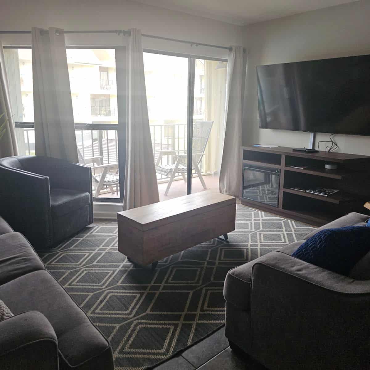 living room with couch and chairs, flatscreen tv over a cabinet