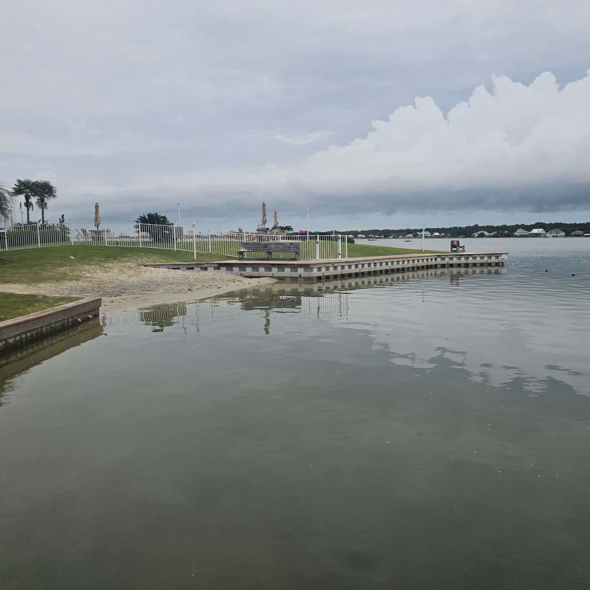 looking over the water to a sandy beach with a pool in the distance on Little Lagoon