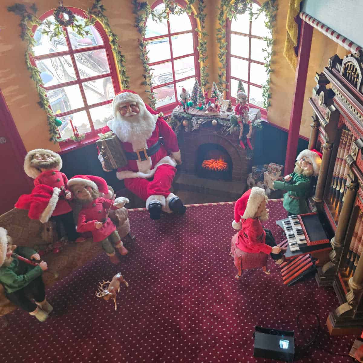 Christmas decoration scene with elves and santa by the fire
