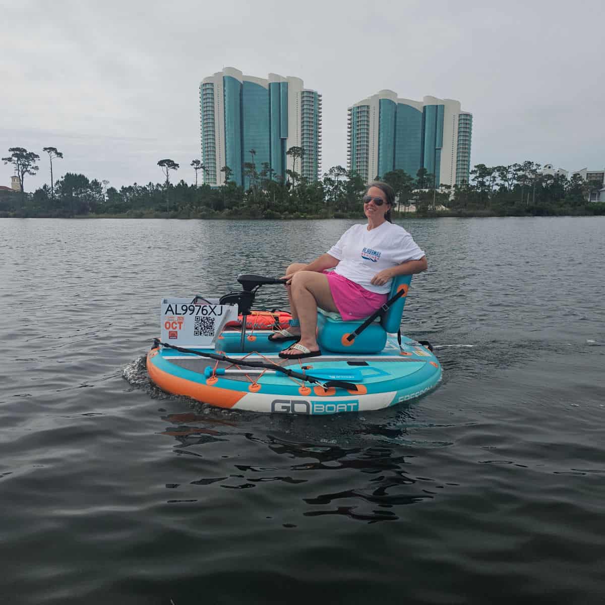 Female sitting on a circle boat with Turquoise Place condos in the background.