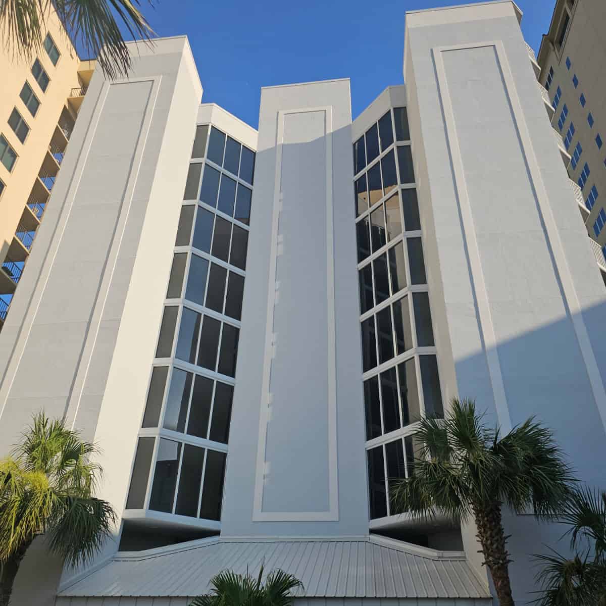 multi-story condo building with large glass windows