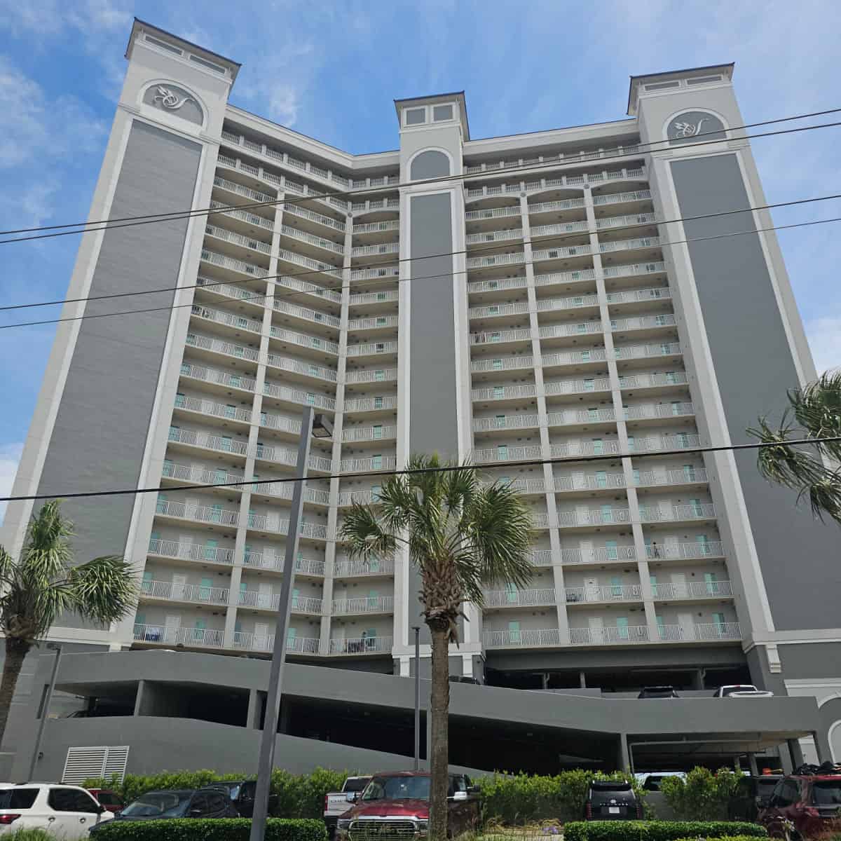 Seawind Condo exterior with palm trees and parking in the front