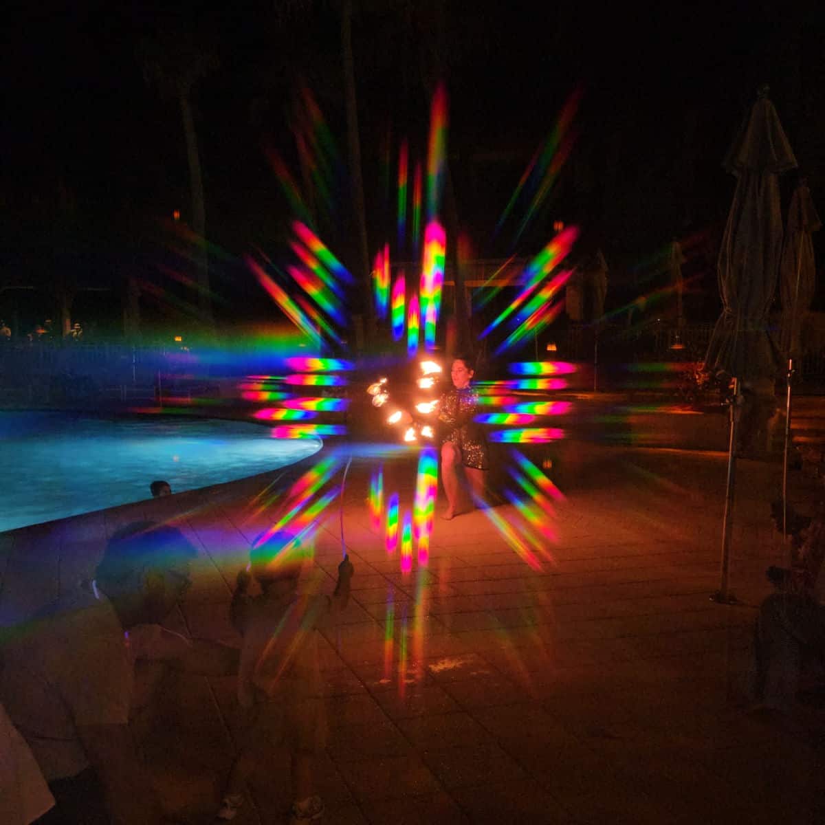 3-d glasses effect around a fire dancer on the pool deck