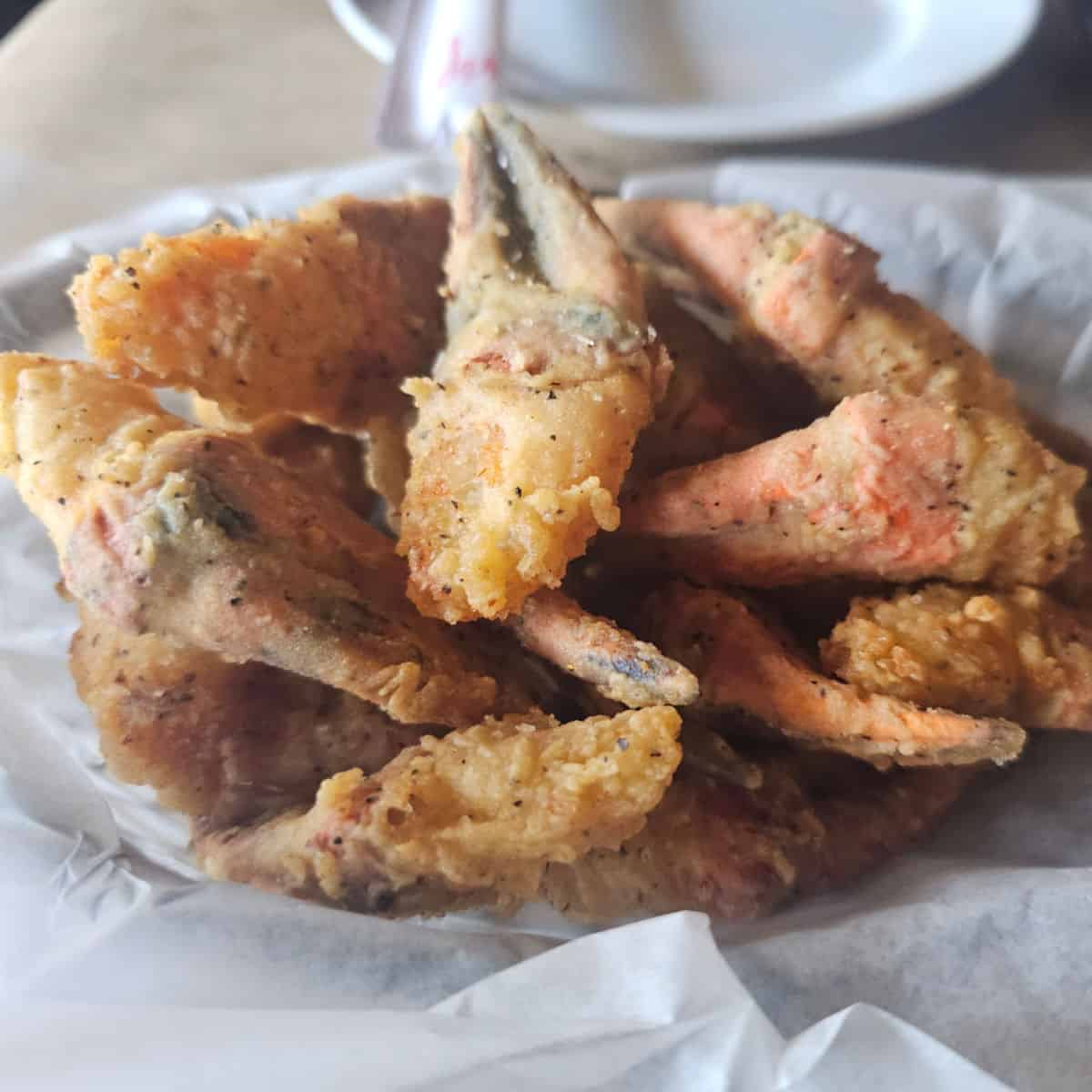 Fried crab claws in a white paper lined dish