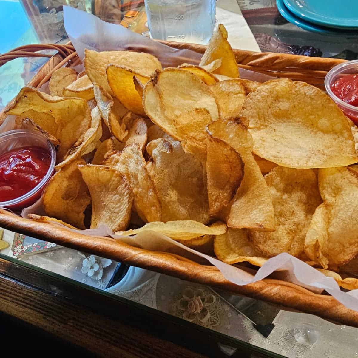 basket of potato chips with ketchup in small containers